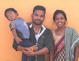 Father holding small child next to mother